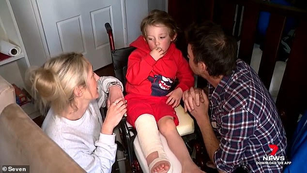 Jemma Holcroft (left) and Ben O'Neill (right) comfort their son Archie who broke his leg after being 'knocked over' by dogs running loose in the park