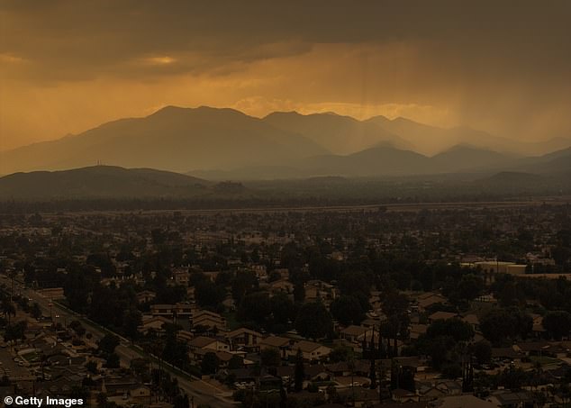 An aerial view of a mix of rain and smoke from the nearby Line Fire creates heavy air pollution on September 8, 2024 over San Bernardino, California