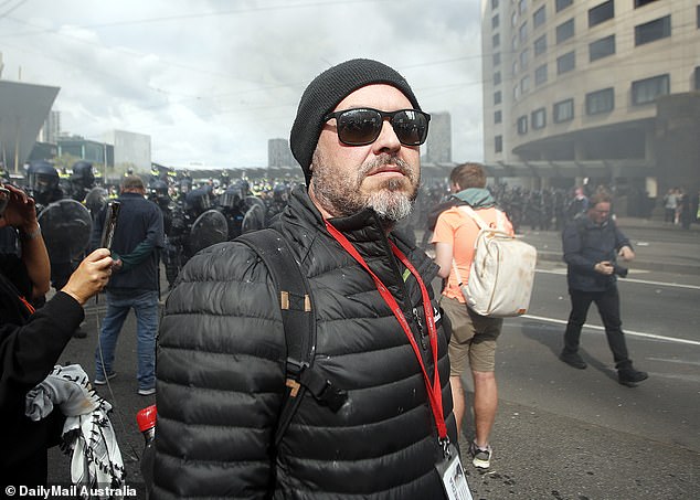 Wayne Flower is pictured at the protest at the Melbourne Convention Centre on Wednesday. He is a seasoned reporter on the streets of Melbourne