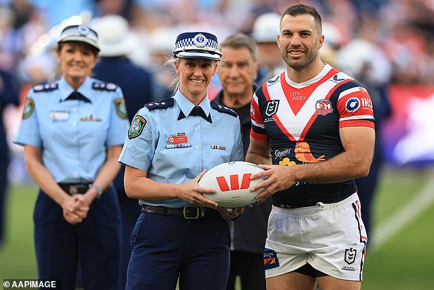 Detective Inspector Amy Scott hands over the football to Roosters captain James Tedesco