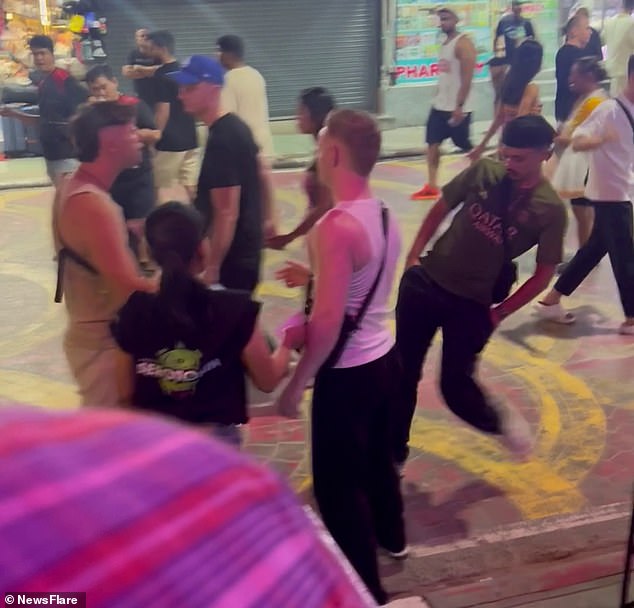 Locals and other tourists watched as one of the men pushed his partner (pictured) after becoming enraged by his 'teasing' over a failed attempt to impress a local woman.