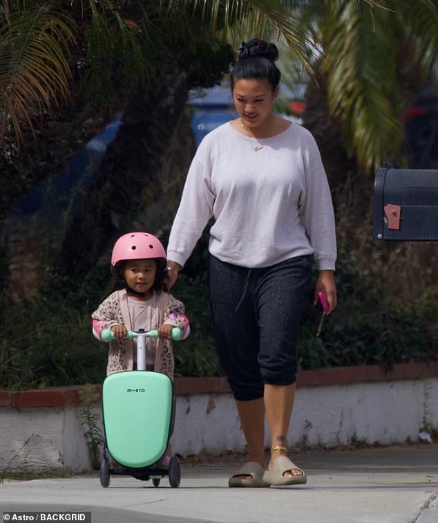 She was seen watching over her daughter as the little one enjoyed a ride on the scooter