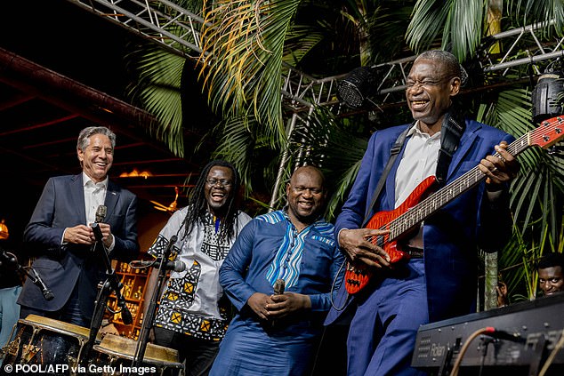 During a visit to Kinshasa in August 2022, Mutombo plays guitar as US Secretary of State Anthony Blinken (left) looks on