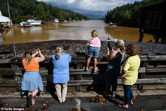 A family looks at the village that was torn to shreds by the powerful floods