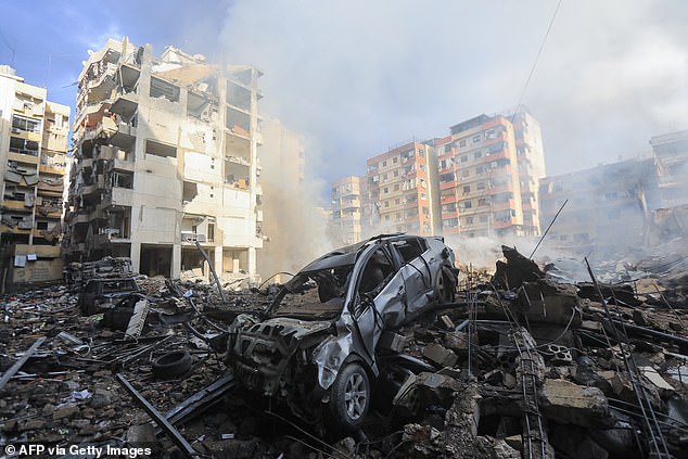 Smoke seeps from construction rubble at the site of a nighttime Israeli airstrike on the Laylaki neighborhood in Beirut's southern suburbs on October 1, 2024