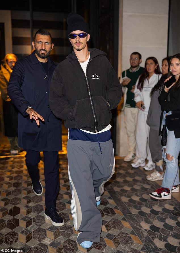 He added a plain white T-shirt and a faded Balenciaga hoodie to his sporty look and completed his ensemble with a beanie, retro sunglasses and baby blue shoes.