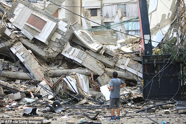 A man looks at the destruction today at the site of an overnight Israeli airstrike on the Ruwais neighborhood in Beirut's southern suburbs