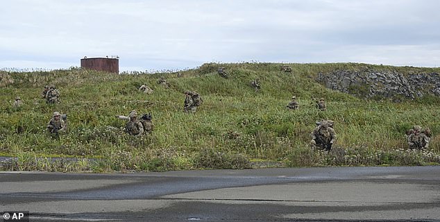 U.S. Army soldiers maneuver through the dense terrain of Shemya Island, Alaska, on September 13, as part of a force projection operation to the remote island in the North Pacific Ocean.