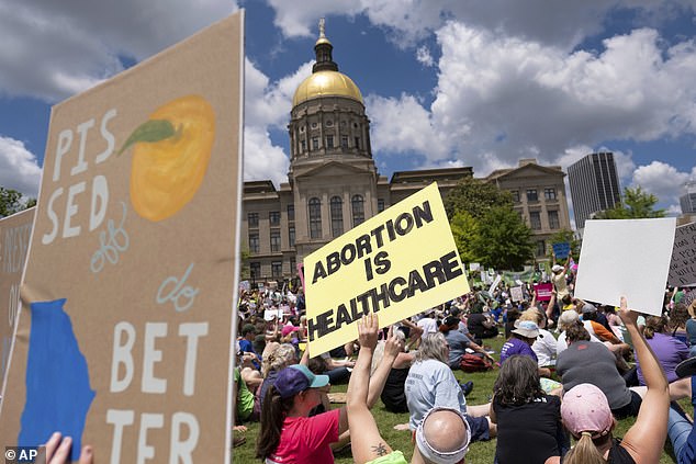 A judge in Georgia on Monday struck down the state's six-week abortion ban after ruling it unconstitutional. Terminations of pregnancy are now legal in the state until about 22 weeks. Pictured: Anti-abortion rights protesters gather at the Georgia State Capitol in Atlanta on May 14, 2022.