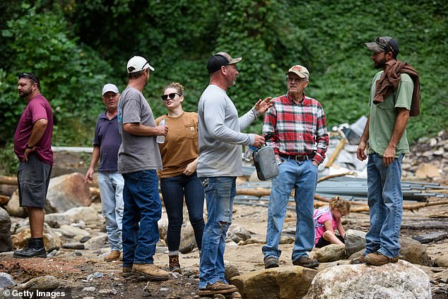 Residents separated from the city center by a washed-out road discuss their experiences in the aftermath of Hurricane Helene on September 30, 2024 in Old Fort, North Carolina