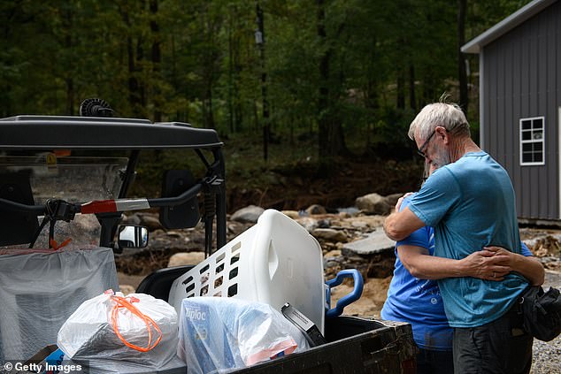 Ron Grindstaff, right, comforts his wife Marie as they remove belongings from their home in the aftermath of Hurricane Helene in Old Fort, North Carolina