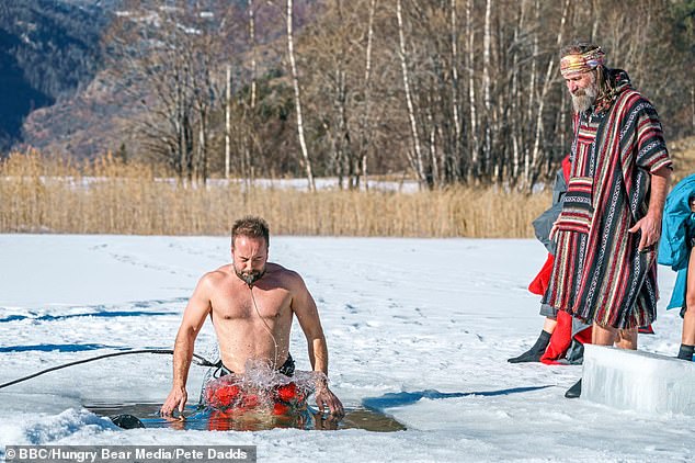 He taught celebrities how to keep their bodies and mental health in check with sub-zero ice challenges. Pictured is a poncho-wearing Hof watching Alfie Boe take the plunge