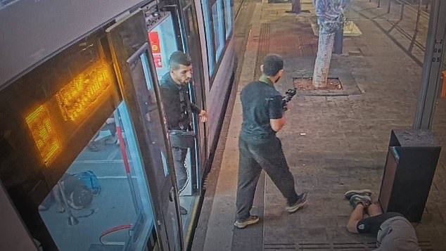 Pictured: men with guns on the streets of Tel Aviv