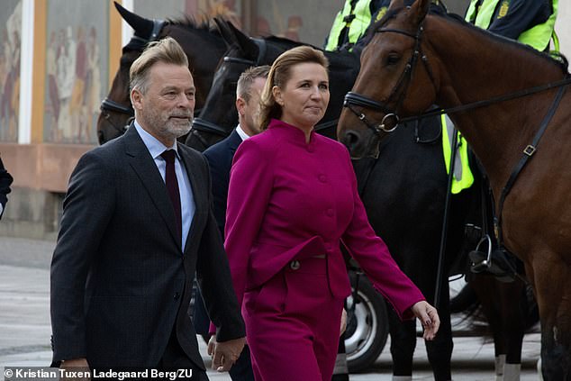 Prime Minister Mette Frederiksen (right), the youngest prime minister in Danish history, was dressed in a dark pink pantsuit, while her husband Bo Tengberg (left) looked dapper in a dark suit and tie