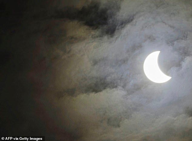 In a partial solar eclipse, the sun is only partially covered by the moon, making it appear as if a 'bite' has been taken out of the sun: Pictured: A partial solar eclipse at Skegness in Lincolnshire, England, March 20, 2015