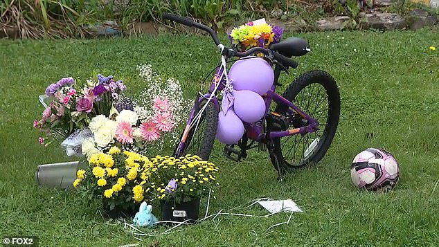 A memorial was erected on the family's front lawn Monday with flowers, a soccer ball, stuffed animals and the little girl's purple bicycle.