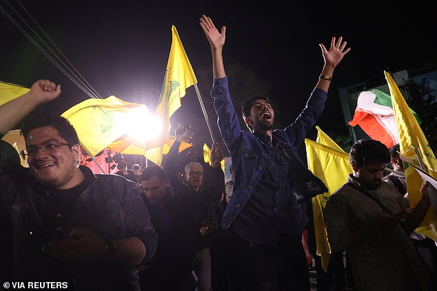 Iranians celebrate in the streets after a barrage of rockets was unleashed on Israel