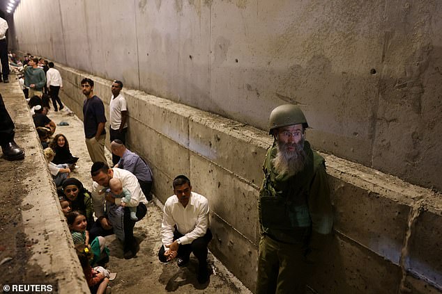 People seek shelter during an air raid amid cross-border hostilities between Hezbollah and Israel