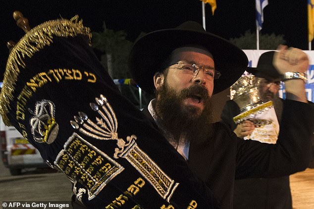 Jews dance with Torah scrolls during the Simhat Torah celebration in the Mediterranean coastal city of Netanya, north of Tel Aviv, on October 8, 2012