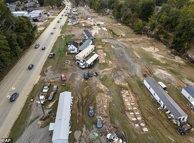 Homes and vehicles damaged during flash flooding from Hurricane Helene lie on the side of a road near the Swannanoa River in Swannanoa, North Carolina