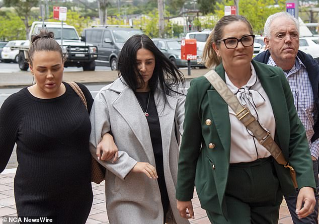 She linked arms with her sister and did not answer questions from reporters as she walked into court