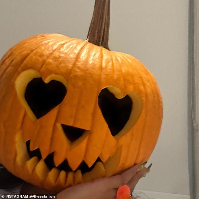 In the photos, the artist also wore the carved pumpkin while nibbling on a large bowl of popcorn