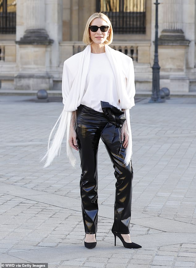 The 55-year-old Australian exuded effortless French chic in patent leather trousers with a low-cut hip and a statement leather bow