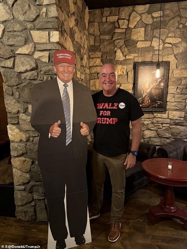 Donald Trump Jr. shared a photo of a distant relative of Kamala Harris' running mate wearing a 'Walz for Trump' T-shirt as he stood next to a cardboard cutout of the Republican candidate