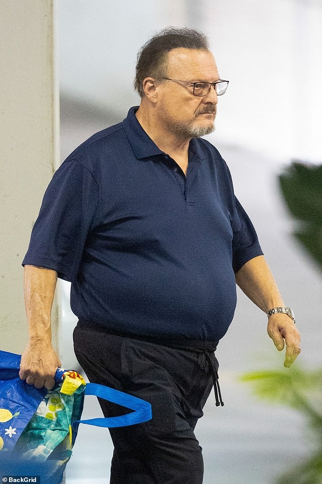 In one hand he carried reusable shopping bags