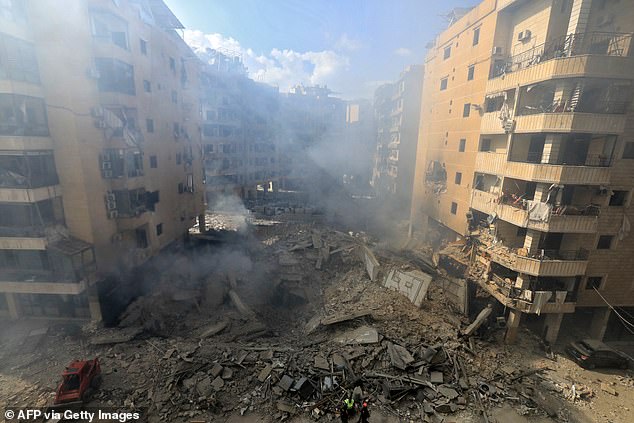 Rescue workers check the destruction at the site of an overnight Israeli airstrike in Beirut's southern Shayyah suburb