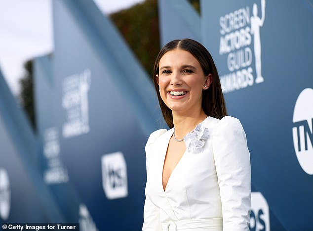 The photos show the couple exchanging vows under a beautiful floral arch as the Stranger Things actress, 20, stuns in her custom Galia Lahav dress; (photo 2020)