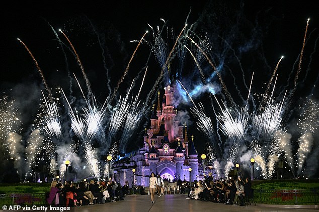 As the models take to the catwalk, fireworks rain down around Disneyland's most iconic castle