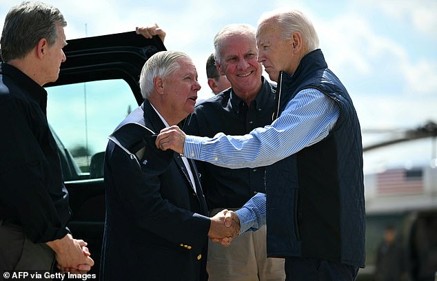 Senator Lindsey Graham (R-SC) greets US President Joe Biden (R) upon arrival at Greenville-Spartanburg International Airport in Greer, South Carolina