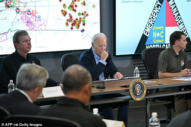 US President Joe Biden (C) and North Carolina Governor Roy Cooper (L) receive an operational briefing at the Raleigh Emergency Operations Center