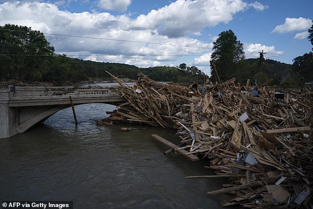 The National Hurricane Center predicts the storm will develop over the northwestern Caribbean Sea and the southern Gulf of Mexico. Pictured: A group of broken pieces of wood from destroyed homes lie along a damaged bridge in Lake Lure, North Carolina