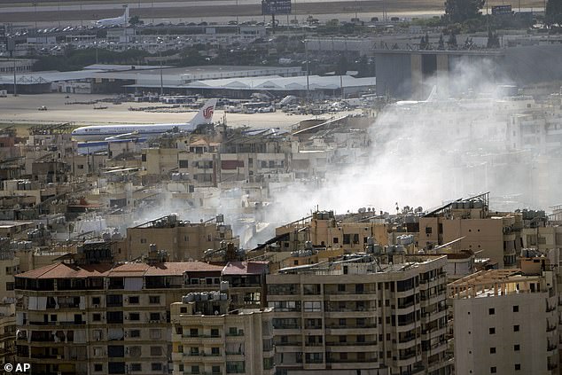 A plane prepares to take off from Rafik Hariri International Airport as smoke rises from the site of an Israeli airstrike in Dahiyeh, Beirut, Lebanon, Tuesday, October 1, 2024