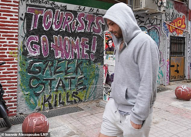 Chilling graffiti in Athens reads: 'Tourists go home! Greek state kills