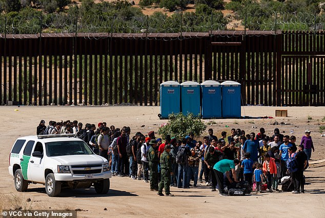 Migrants await processing by U.S. Border Patrol agents after crossing into the U.S. from Mexico in Jacumba Hot Springs, California, on June 14, 2024. FEMA has received more than $1 billion since 2023 to house noncitizens