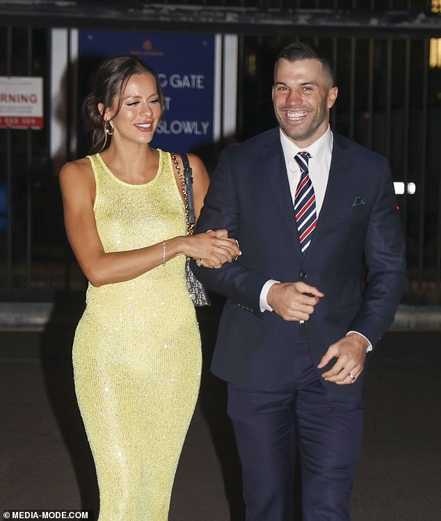 The slinky number stood out against the dark tones of her husband's outfit, and she paired the look with white strappy heels and a black bag.