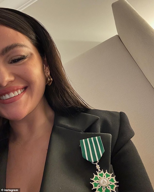 Gomez pinned the striking green medal to the silk lapel of her sexy black blazer dress