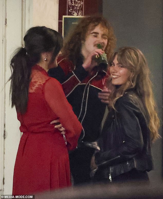 The trio seemed to be having a great time as they chatted with the duo's friend while happily sipping beers as they got ready for the performance