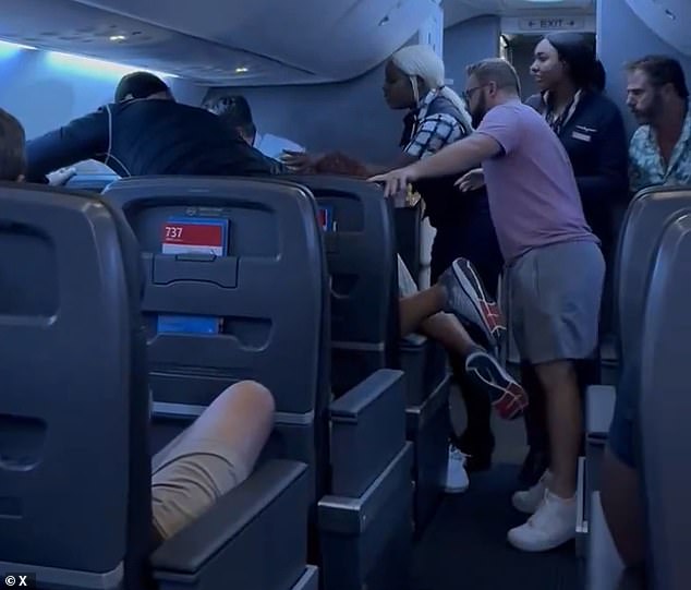 The passengers were seen shouting at the passenger to take his hands off the woman sitting next to him as a female flight attendant tried to mediate