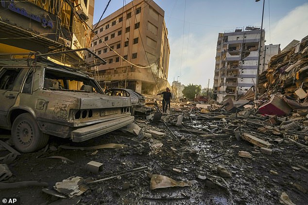 Residents take cover after an Israeli airstrike in Dahiyeh, Beirut, Lebanon, Friday, October 4, 2024