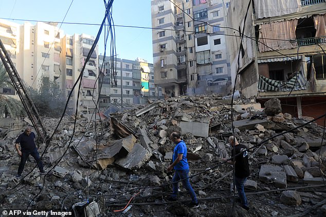 Residents check the destruction in the aftermath of an Israeli attack on the Mreijeh neighborhood in Beirut's southern suburbs on October 4