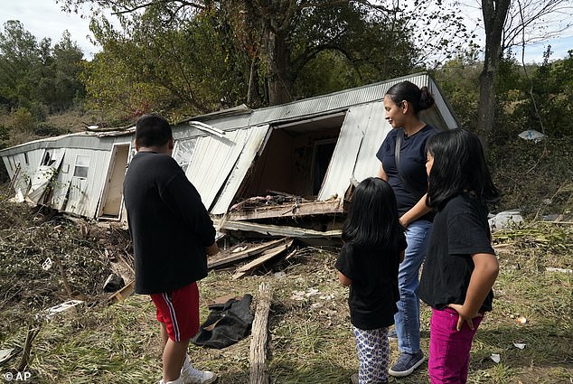 Marisol Juarez and her children stand in front of their family's destroyed mobile home, Tuesday, Oct. 1, 2024, in Hendersonville