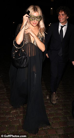 Sienna Miller chose a sheer flowing dress with a gold mask