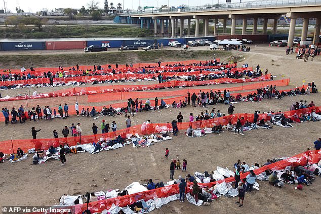 Immigrants await processing at a U.S. Border Patrol transit center after crossing the border from Mexico in Eagle Pass, Texas, on December 20, 2023