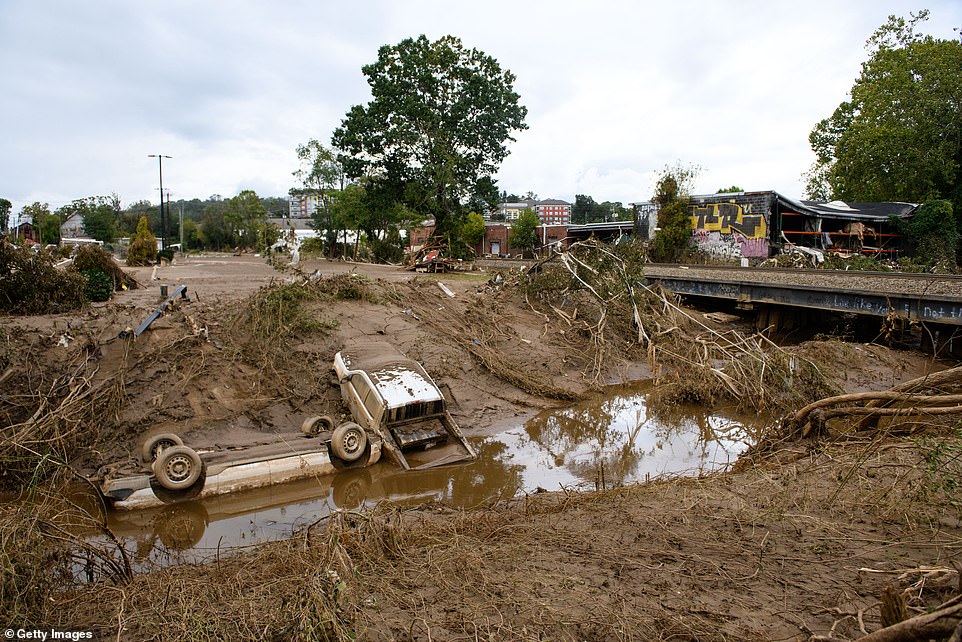 Destroyed cars lay in the water in the Biltmore Village across from the Biltmore Estate in the aftermath of Hurricane Helene on October 1