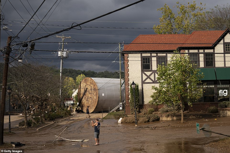 People inspect flood damage in Biltmore Village in the aftermath of Hurricane Helene on September 28, 2024 in Asheville, North Carolina