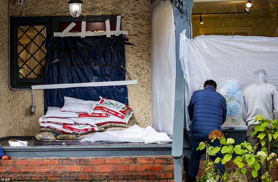 Business owners covered their buildings with plastic and laid down sandbags to curb flooding in a desperate attempt to prepare for the hurricane in Biltmore Village